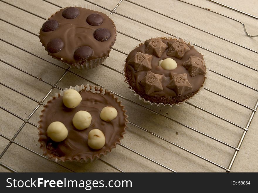 Three Chocolate Cupcakes cooling on a wire tray