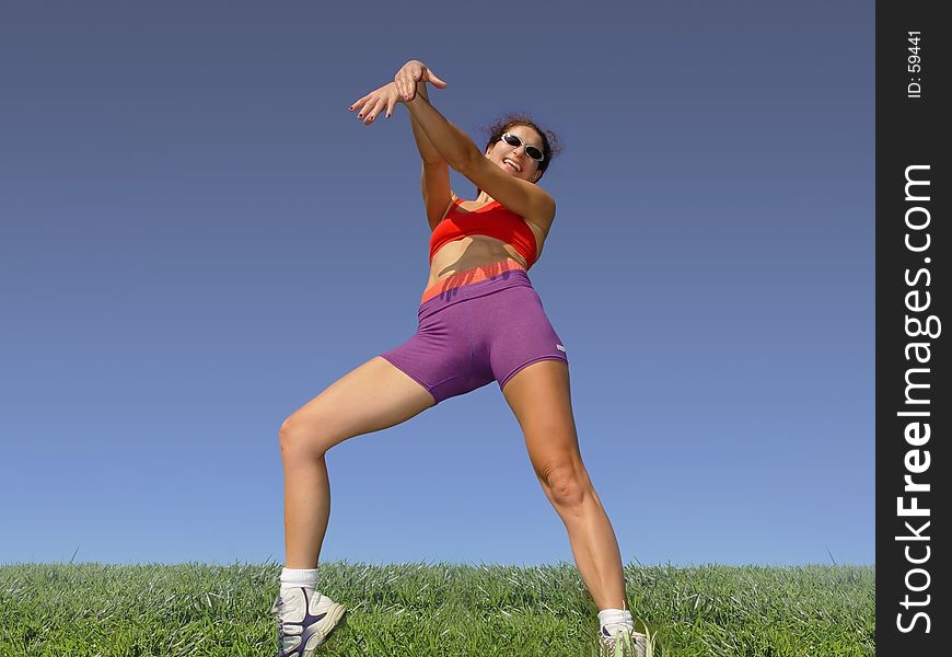 Girl exercising outdoors on the grass