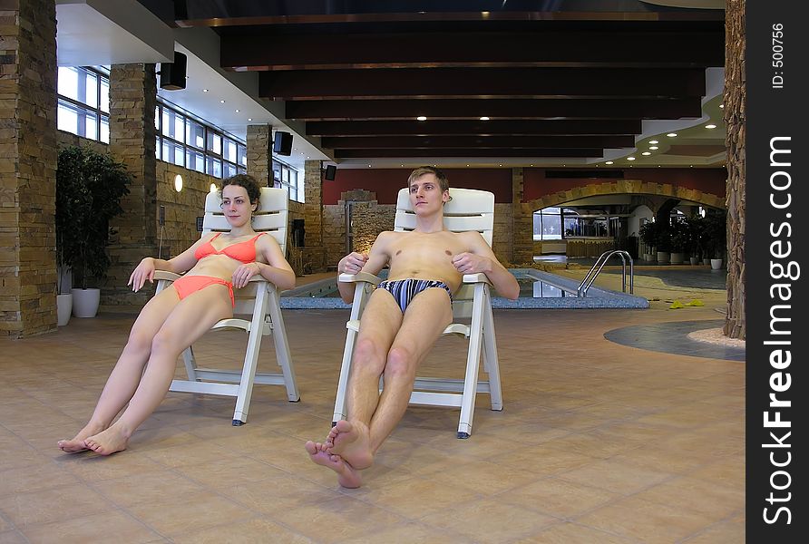 Couple on chairs and swimming pool