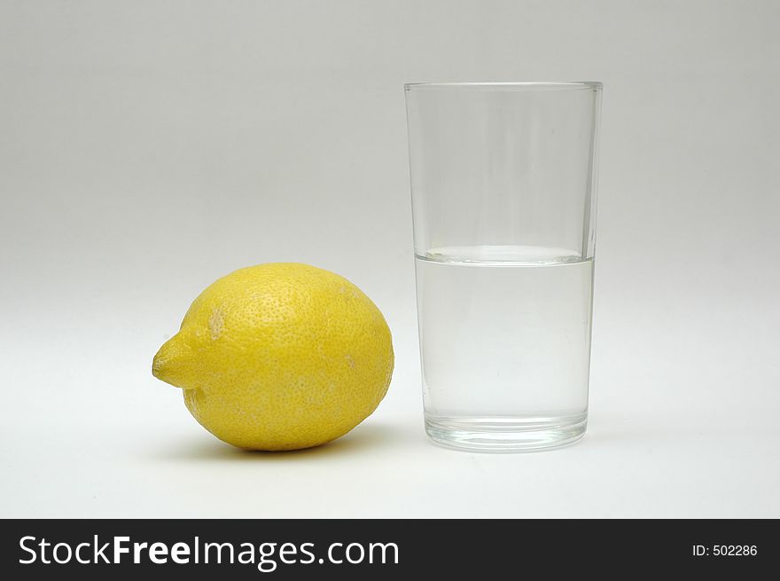 Yellow lemon and a glass of water. Yellow lemon and a glass of water.