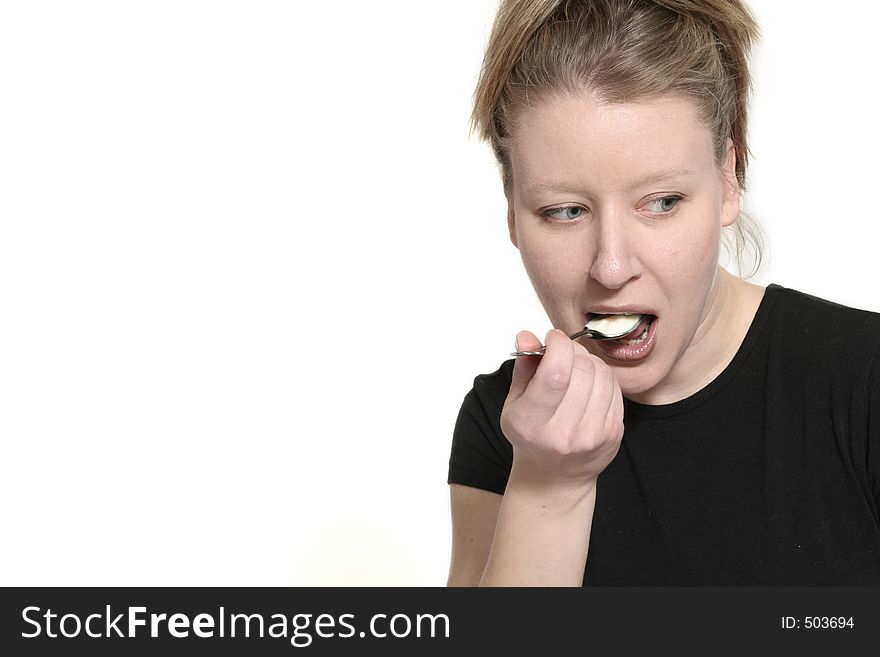 Woman eating yogurt and look on the side