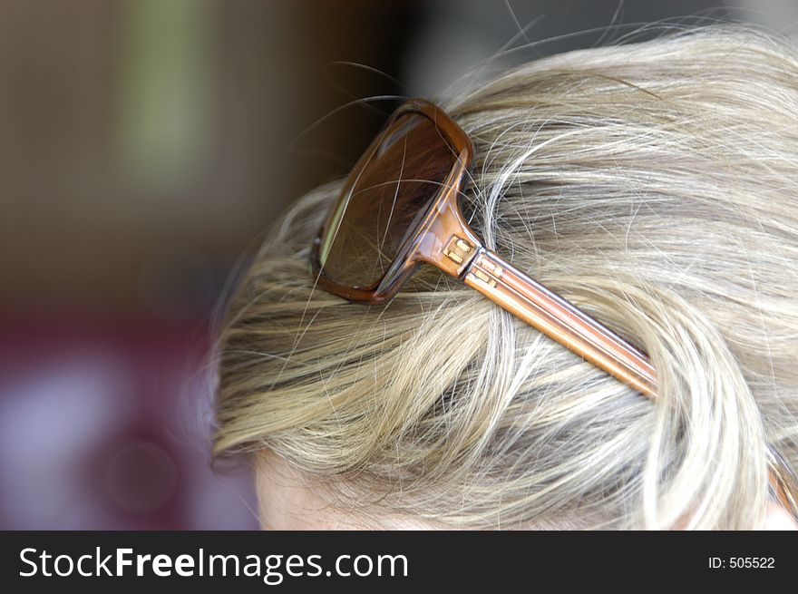 Sunglasses balanced on blonde hair. Sunglasses balanced on blonde hair