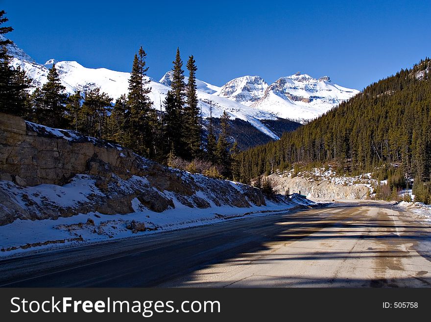 A beautiful scene on a highway in the mountains during mid winter. A beautiful scene on a highway in the mountains during mid winter.