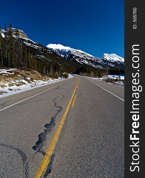 A scenic highway cuts into the mountains in mid winter. A scenic highway cuts into the mountains in mid winter.