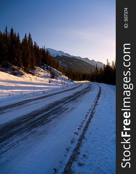 An icy curve in the road early morning in the mountains.