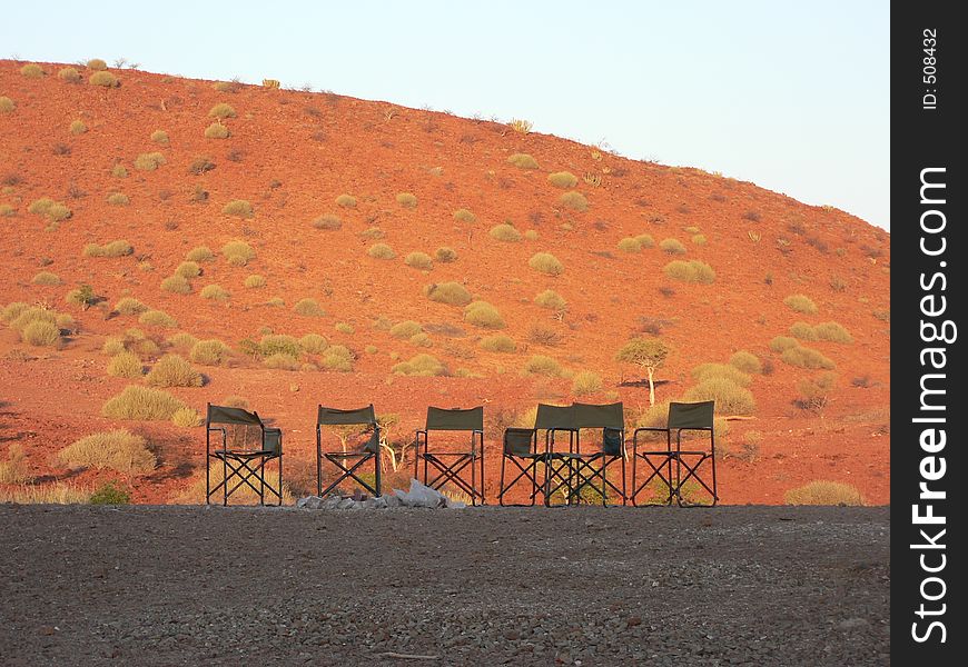 Campfire taken at sunset, empty chairs waiting for the evening when people chat and look at the stars. Campfire taken at sunset, empty chairs waiting for the evening when people chat and look at the stars