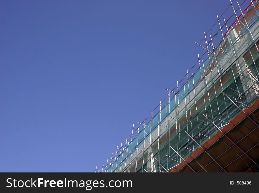 Scaffolding at a construction site against a blue sky - copy space