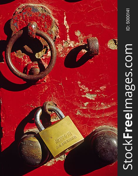 Traditional knocker and new lock on a red door, the forbidden city, china. Traditional knocker and new lock on a red door, the forbidden city, china