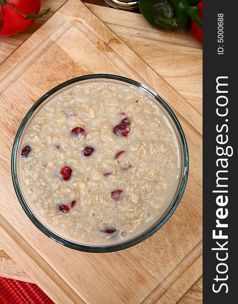 Oatmean and craisins (dried cranberries) in glass bowl in kitchen or restaurant. Oatmean and craisins (dried cranberries) in glass bowl in kitchen or restaurant.