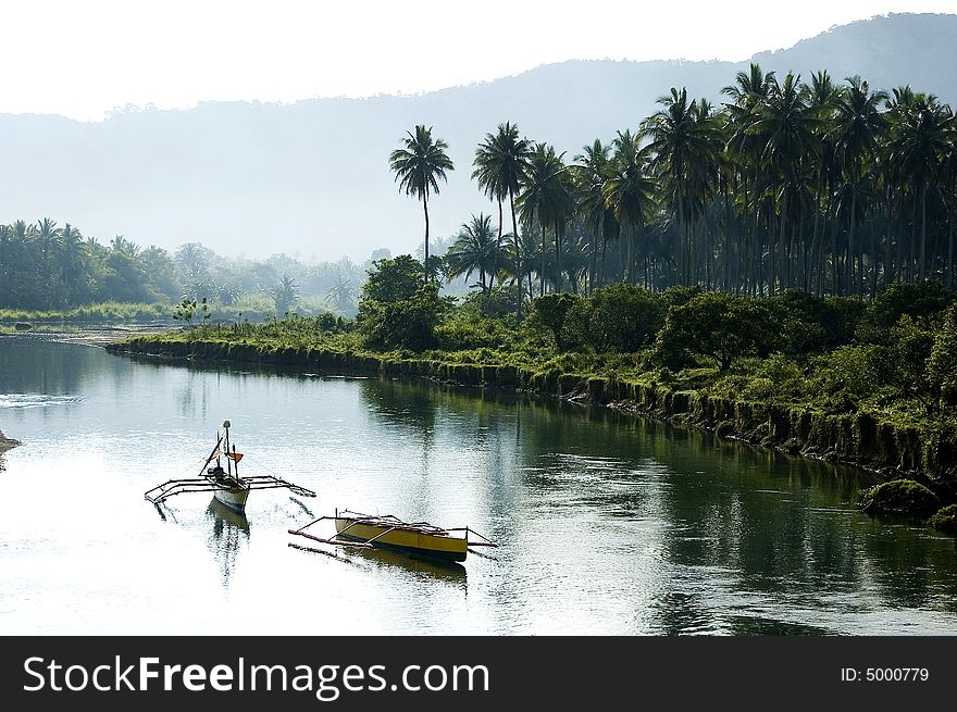 Two boats floating in the river bank near the coconut fields in the Provonce of Aurora. Two boats floating in the river bank near the coconut fields in the Provonce of Aurora.