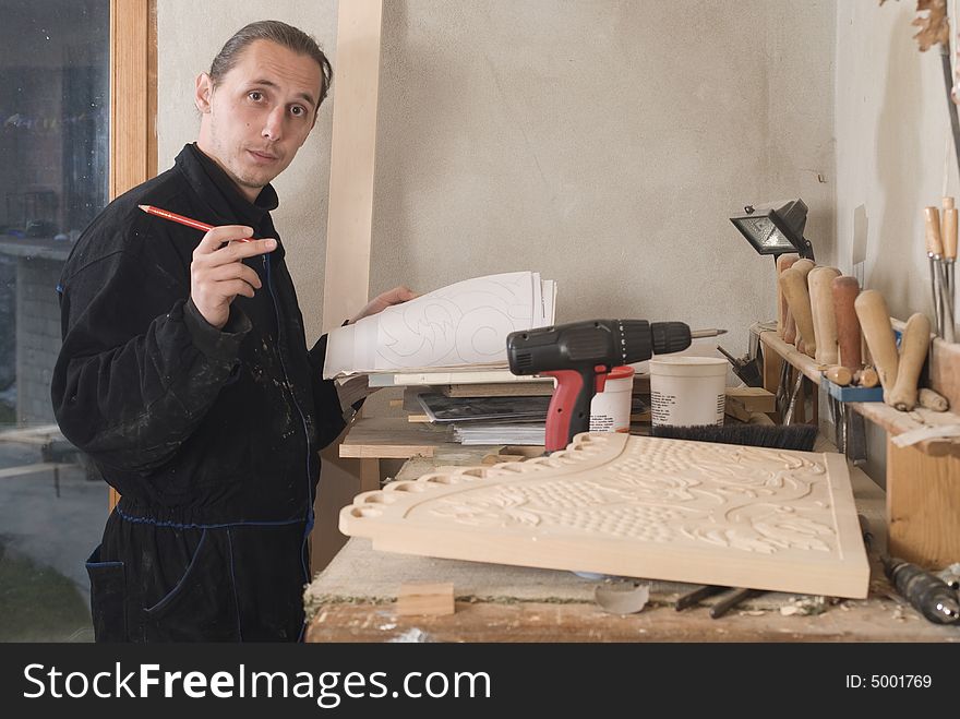 Young carpenter in his workshop with craft pencil and planning of his work