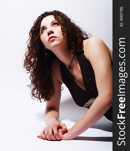 A portrait about an attractive lady with white skin and long brown wavy hair who wears a nice dark dress, she is laying, looking up and desires something. A portrait about an attractive lady with white skin and long brown wavy hair who wears a nice dark dress, she is laying, looking up and desires something