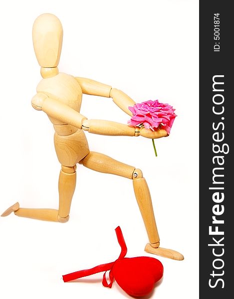 Wooden figurine man holding rose, standing on knees. Wooden figurine man holding rose, standing on knees