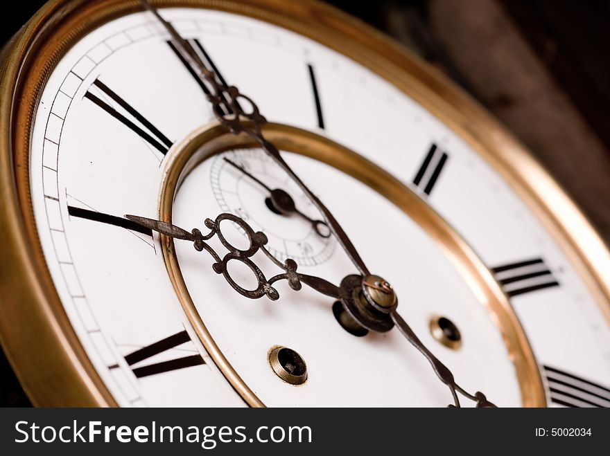 Old clock face with roman numerals - focus on hour hand. Old clock face with roman numerals - focus on hour hand.