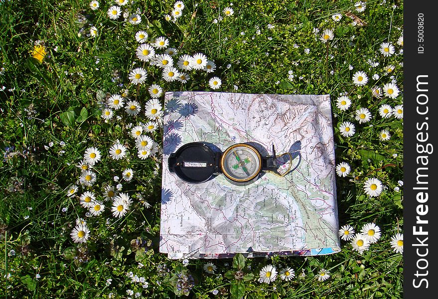 Compass and map of french mountains on grass. Compass and map of french mountains on grass