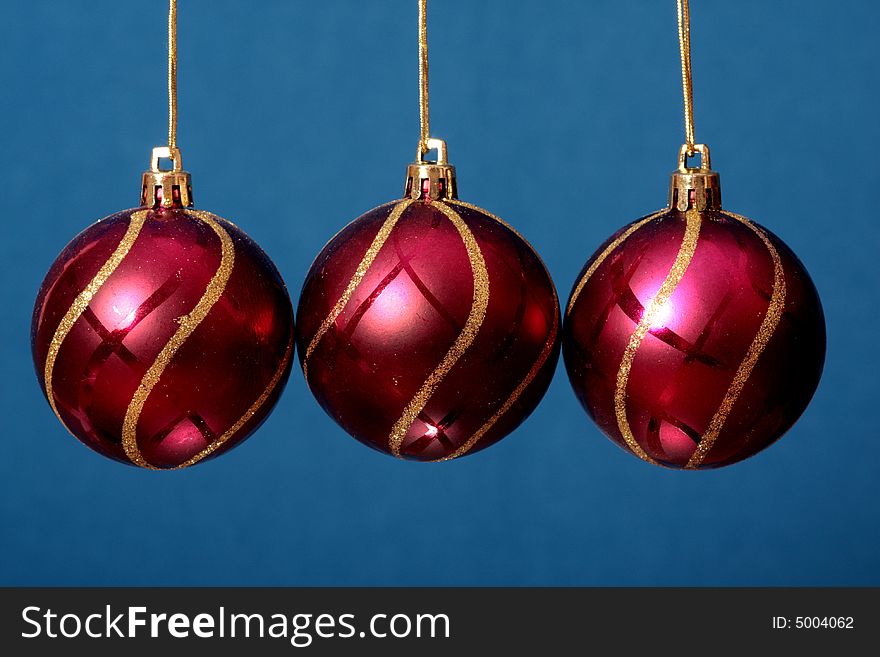Three red New Year's spheres on a blue background