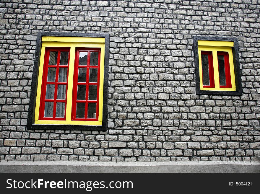 Yellow and red windows on stone wall