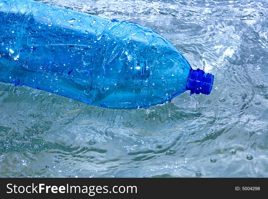 Blue bottle in water splash