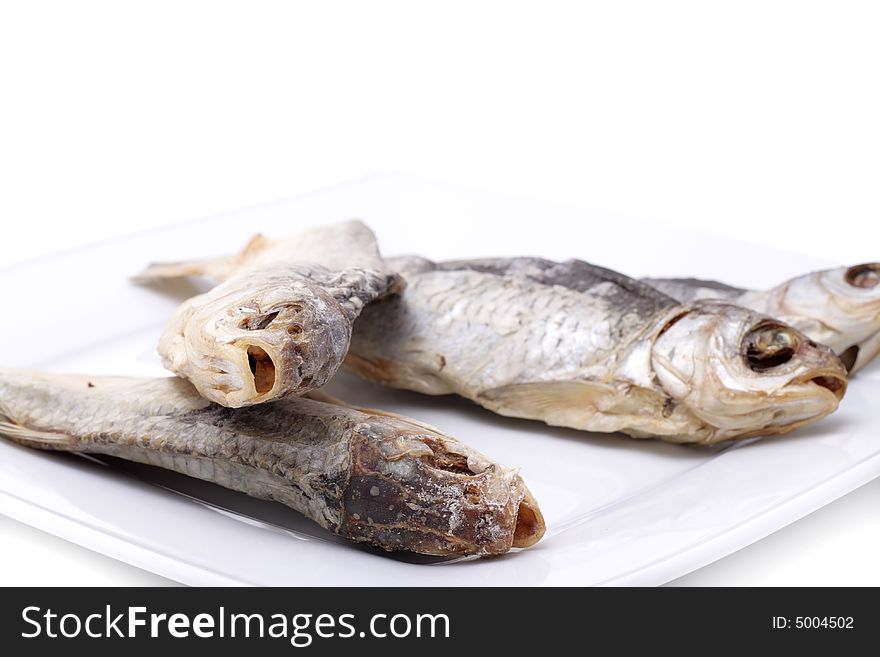 Dried fish on a plate. Isolated on a white background