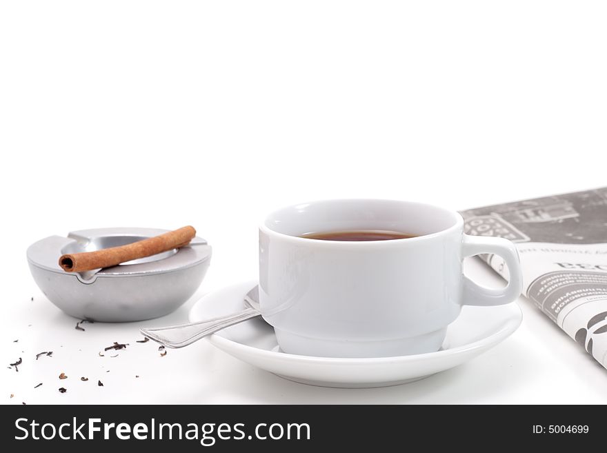 Brown teas, cinnamon in a ashtray and newspaper isolated on white background. Brown teas, cinnamon in a ashtray and newspaper isolated on white background