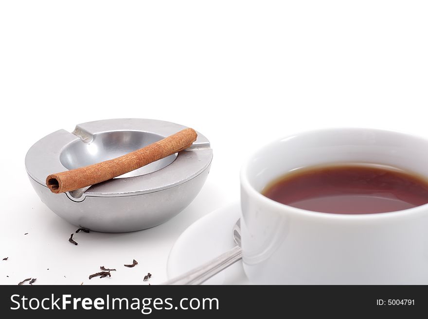 Brown teas, cinnamon in a ashtray and newspaper isolated on white background. Brown teas, cinnamon in a ashtray and newspaper isolated on white background