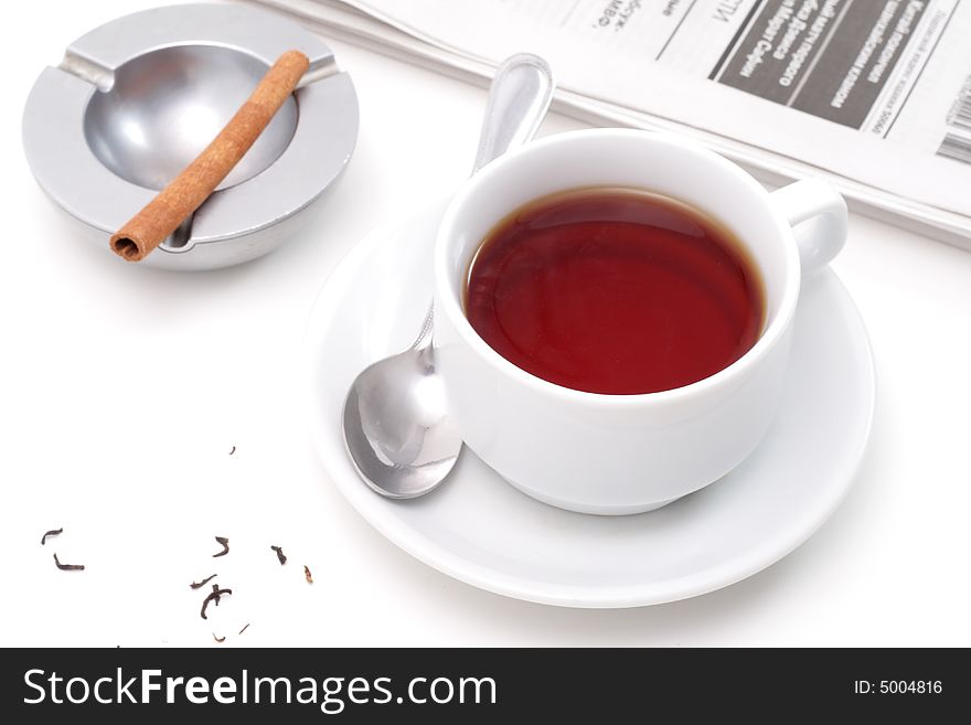 Brown teas, cinnamon in a ashtray and newspaper isolated on white background. Brown teas, cinnamon in a ashtray and newspaper isolated on white background