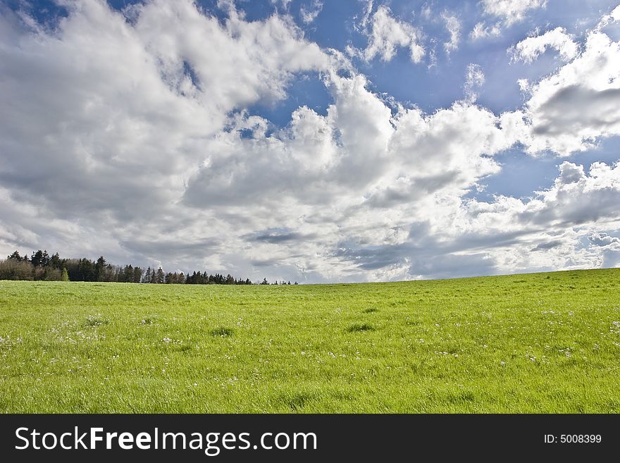 The storm is over: cloudy blue sky on green field. The storm is over: cloudy blue sky on green field