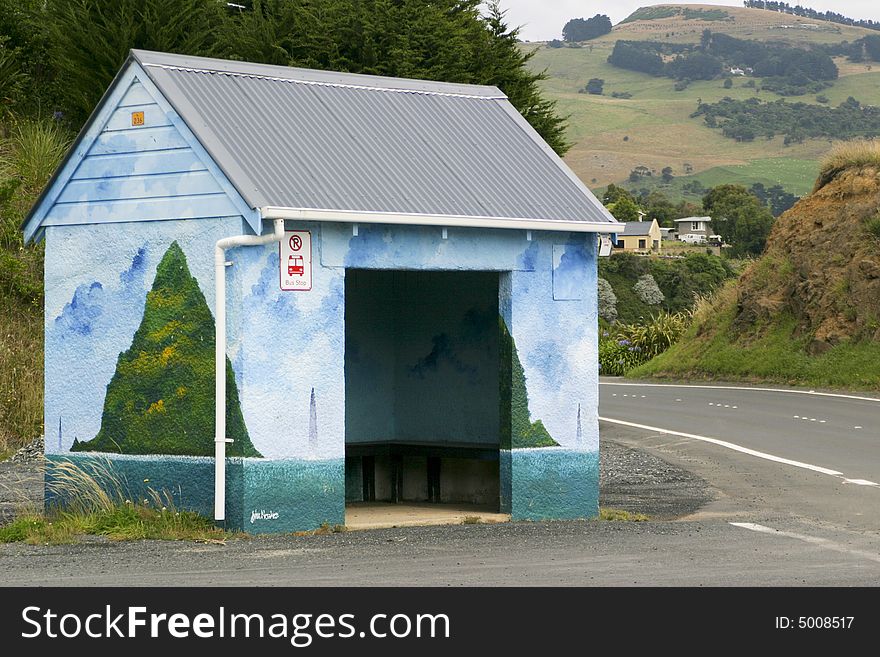 A brightly painted bus stop shelter in the country. A brightly painted bus stop shelter in the country