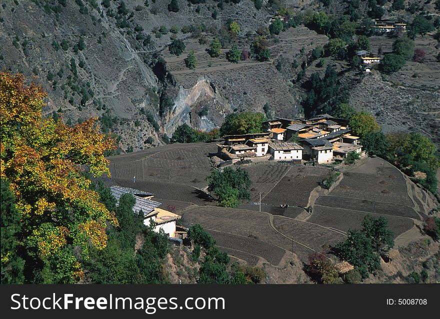 Village and field at the top of a sheer cliff.