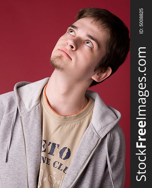 The young guy in studio on a red background