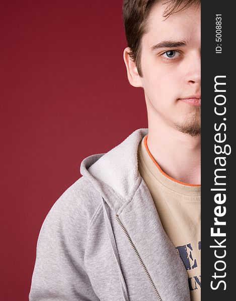 The young guy in studio on a red background