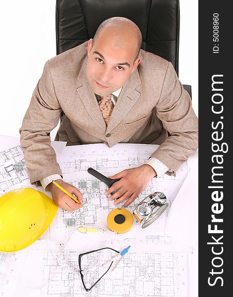 A businessman happiness with architectural plans at desk