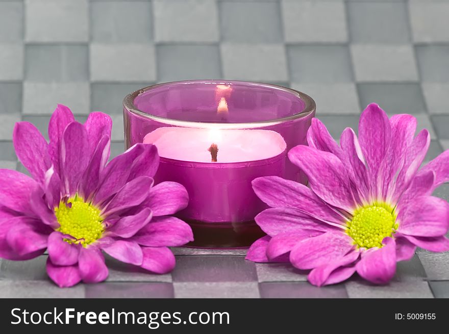 Spa candle with flowers on grey background
