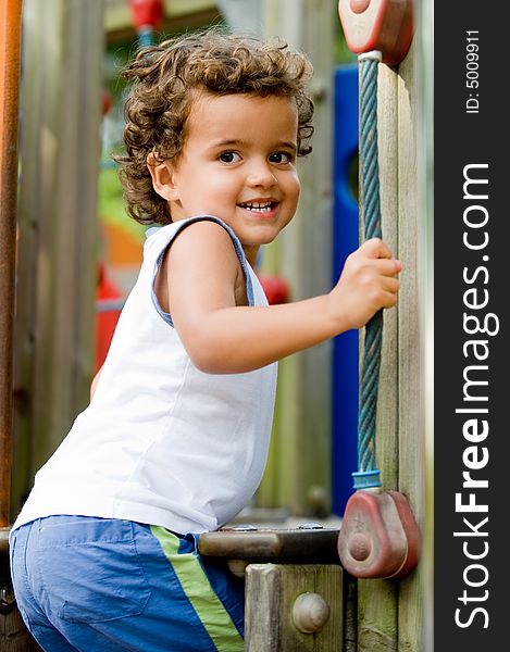 A cute young kid playing on a climbing frame in a park. A cute young kid playing on a climbing frame in a park