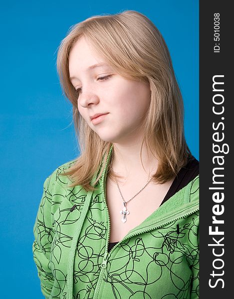 The young girl in green clothes on a dark blue background. The young girl in green clothes on a dark blue background.