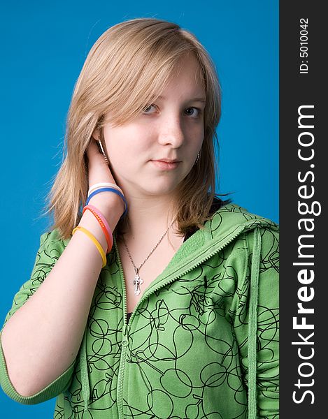 The young girl in green clothes on a dark blue background. The young girl in green clothes on a dark blue background.