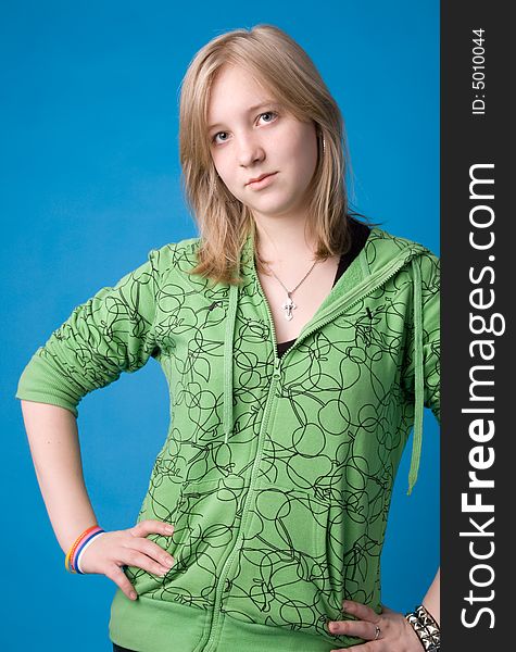 The young girl in green clothes on a dark blue background. The young girl in green clothes on a dark blue background.