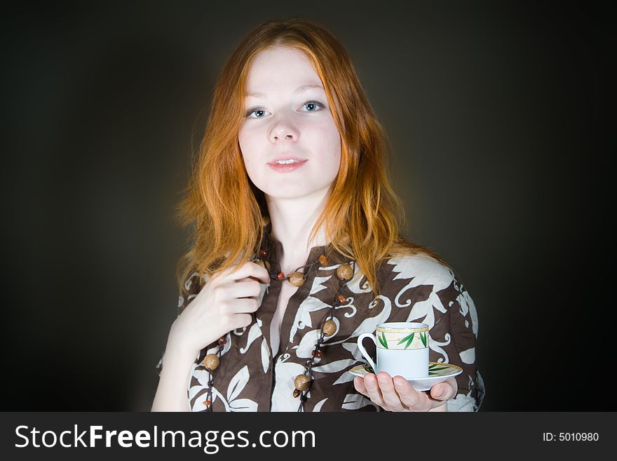 Beautiful woman with cup in hand. Focus on cup.