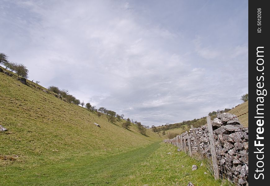 Country track with blue sky and dry stone wall