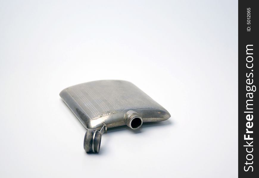 An empty silver flask from the 40s or 50s on a white background. An empty silver flask from the 40s or 50s on a white background.