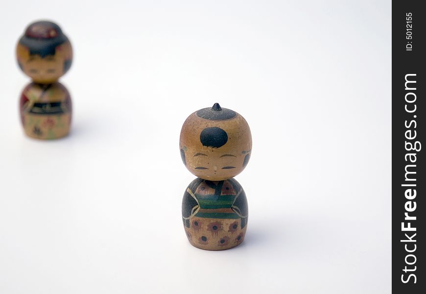 Two wooden Japanese figures on a white background. Two wooden Japanese figures on a white background.