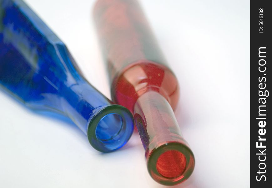 Two glass bottles lying on a white background. Two glass bottles lying on a white background.