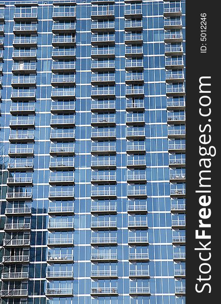 A blue glass wall apartment full of balconies. A blue glass wall apartment full of balconies