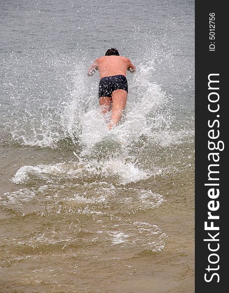 Young man diving into water and making lots of splashes. Young man diving into water and making lots of splashes