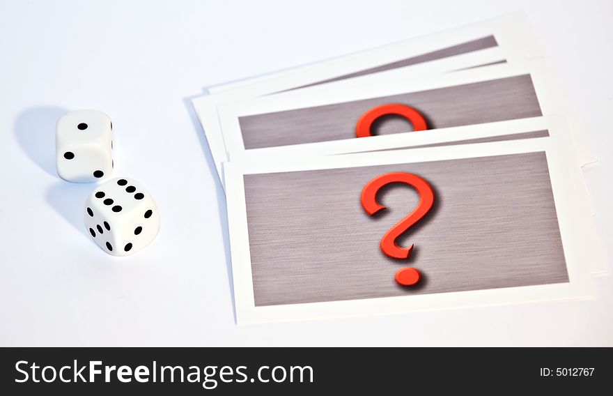 Photo of 2 dice and a set of cards with a question mark on them. Photo of 2 dice and a set of cards with a question mark on them