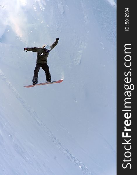 A snowboarder drops in from a high level cornice. Freefalling with powder and snow debrit cascading down from above. A snowboarder drops in from a high level cornice. Freefalling with powder and snow debrit cascading down from above.