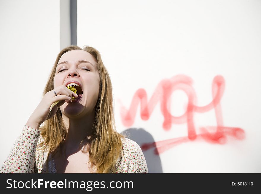 Young woman eating spring flower