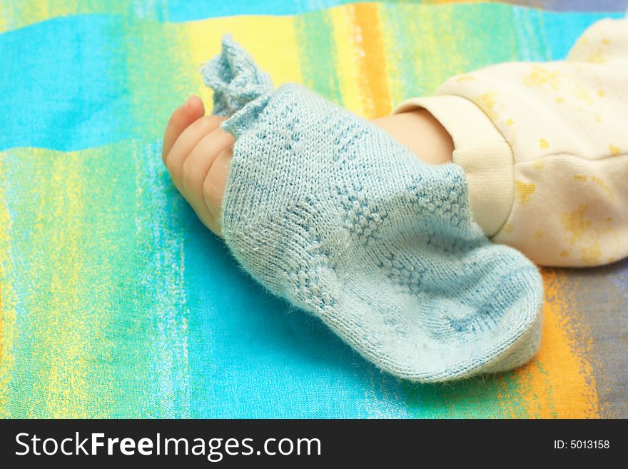 The hand of the child compresses a blue sock. The hand of the child compresses a blue sock