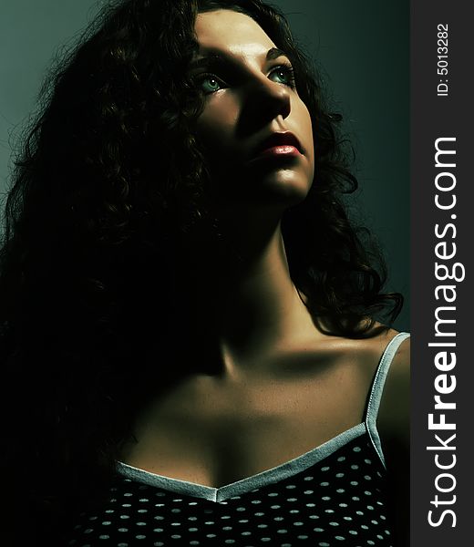 A low-key portrait about a pretty lady with white skin and long brown wavy hair who wears a nice black dress with white dots and she is looking up and desires something. A low-key portrait about a pretty lady with white skin and long brown wavy hair who wears a nice black dress with white dots and she is looking up and desires something