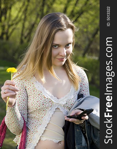 Young Woman with Mobile and flower in park. Young Woman with Mobile and flower in park